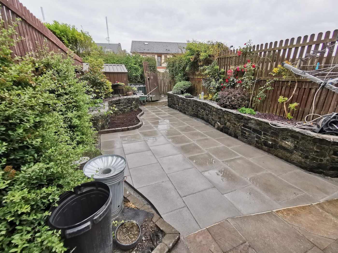 Planted garden border with pots and paving